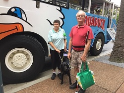 Peter & Jenny and her Seeing Eye Dog Elvis standing in front of the Aquaduck amphibious boat