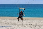 Photograph of Tarhnee still slightly airborne before touching down on the sand at Kirra beach.